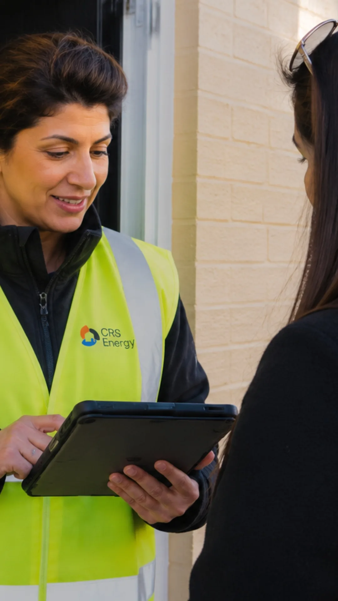 CRS Energy technician reviewing cavity wall insulation documentation with the homeowner on a tablet